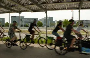 Gruppe von radfahrenden Personen unter Solardach