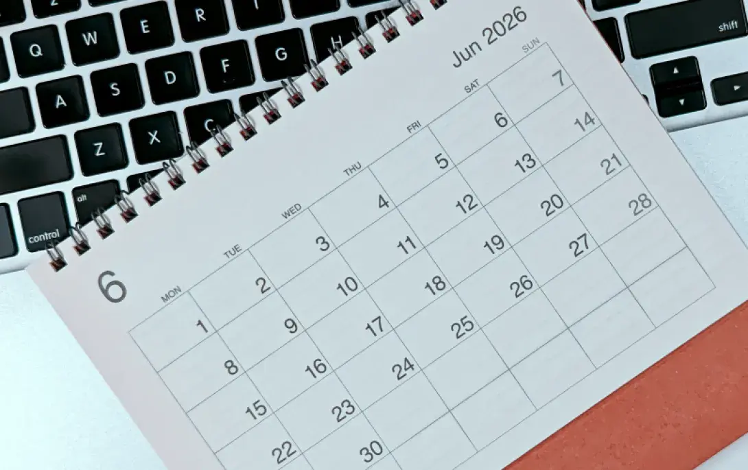 Ein Kalender für den Juni 2026 liegt auf einer Tastatur.