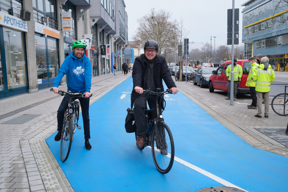 Das Foto zeigt Tübingens Oberbürgermeister Boris Palmer und Baubürgermeister Cord Soehlke fahrradfahrend auf dem neuen Radweg am Europaplatz.