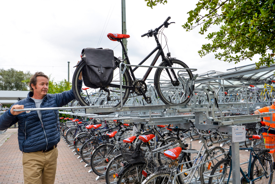 Das Bild zeigt Karl-Heinz Freitag, Mobilitätsreferent des Freisinger Stadtrats, beim Vorführen der Fahrradabstellanlage am Bahnhof.