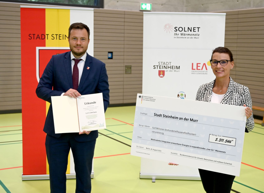 Das Bild zeigt Thomas Winterhalter, den Bürgermeister der Stadt Steinheim an der Murr, und Rita Schwarzerlühr-Sutter, Parlamentarische Staatssekretärin im Bundesumweltministerium bei der Förderscheckübergabe in einer Turnhalle.