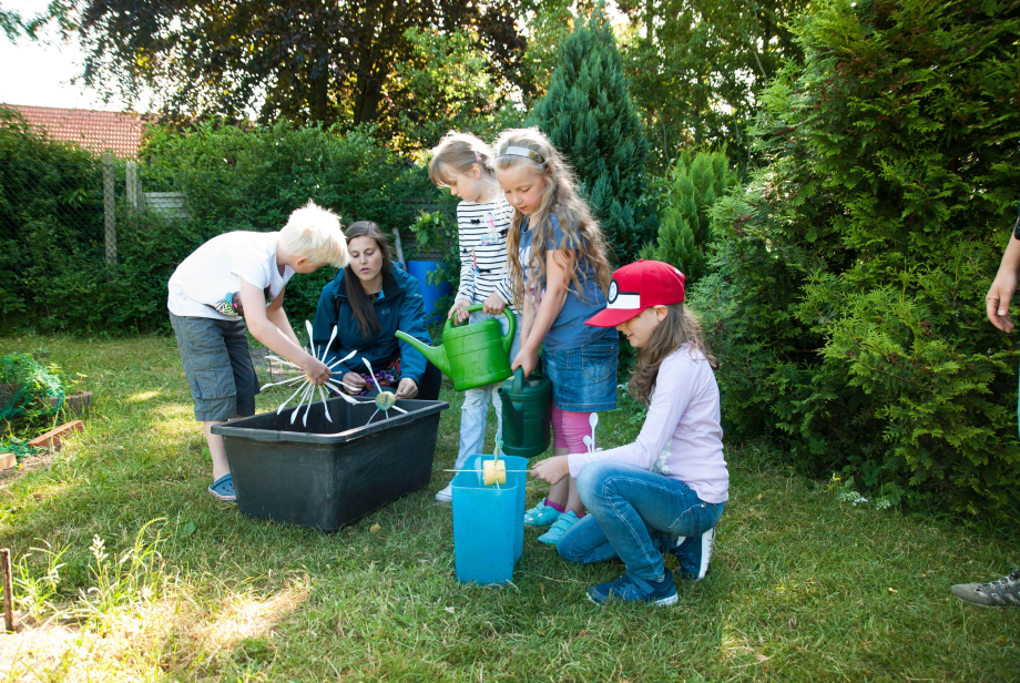 Die kleinen Energiedetektive der Flensburger Falkenbergschule zeigen stolz Jördes Wüstermann (Projekt "Klasse Klima an Flensburger Schulen und Kindertagesstätten") ihre selbstgebauten Wasserräder.