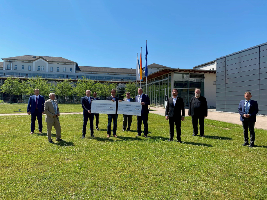 Das Bild zeigt den Parlamentarischen Staatssekretär Florian Pronold und den Bundestagsabgeordneten Uli Grötsch bei der Förderscheckübergabe in der Ostbayerischen Technischen Hochschule Amberg-Weiden.