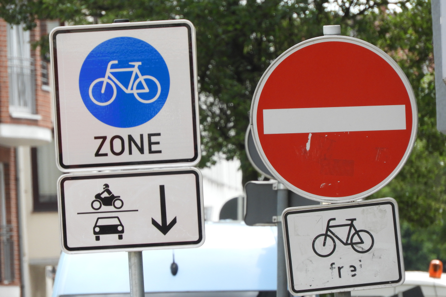 Das Bild zeigt das Straßenschild „Fahrradzone“ und weitere Straßenschilder.