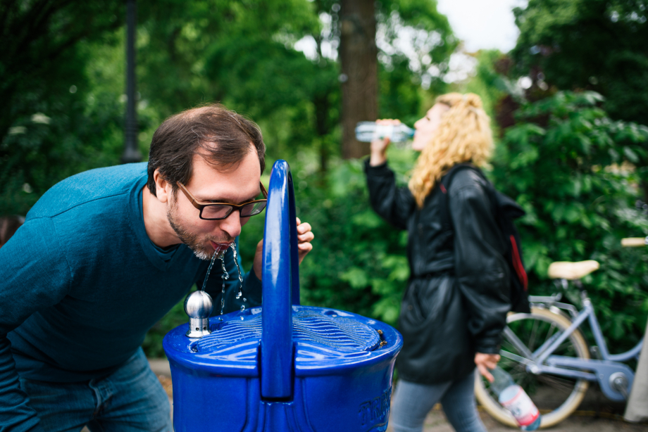 Das Bild zeigt einen Mann, der an einem Trinkbrunnen nutzt.