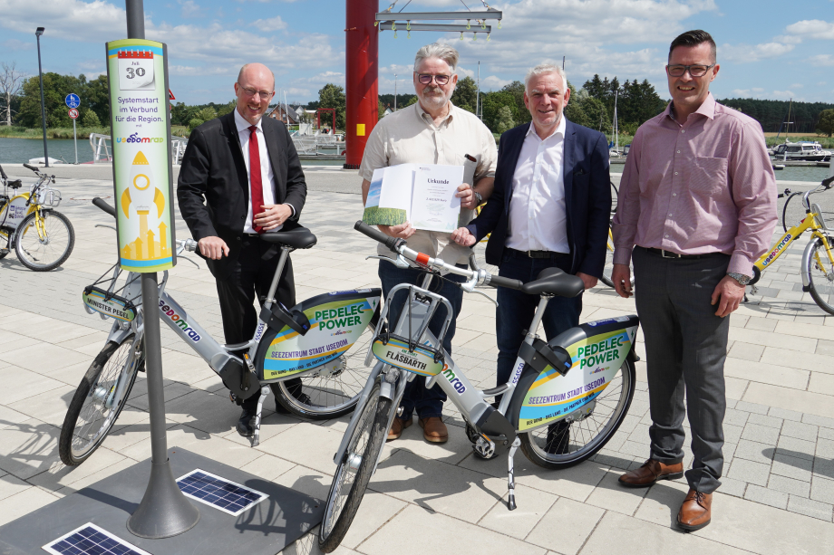 Das Bild zeigt Jochen Flasbarth, Staatssekretär im Bundesumweltministerium, und das Team der Usedomrad GmbH mit zwei Pedelecs.