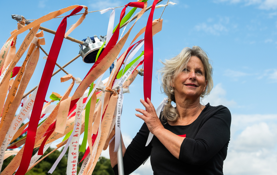 Foto von einer Frau neben einer Holzkonstruktion, die mit vielen Girlanden geschmückt ist.