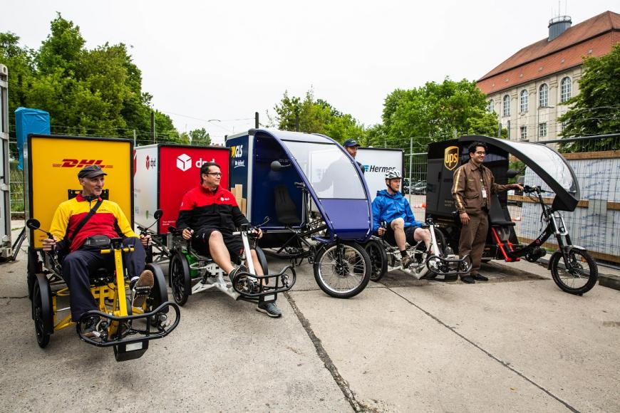 Fahrradkuriere verschiedener Paketdienstleister auf Lastenrädern.