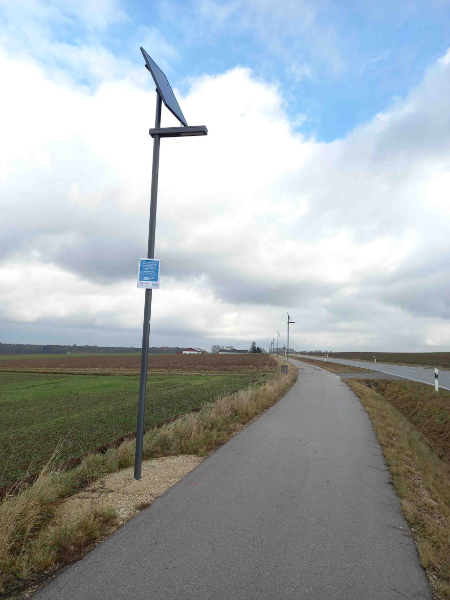 Eine solarbetriebene Beleuchtungsanlage neben einem Radweg.