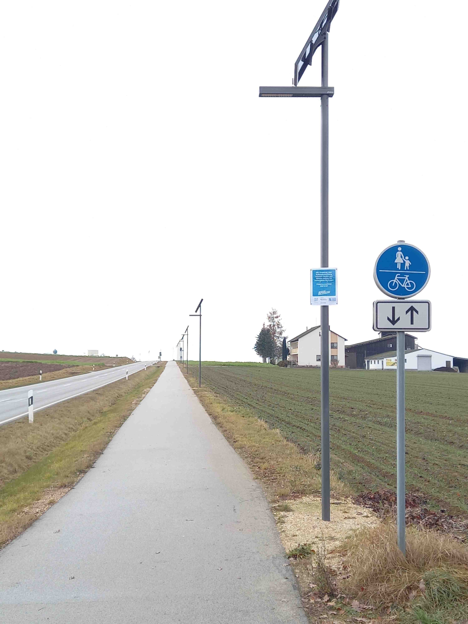 Eine solarbetriebene Beleuchtungsanlage neben einem Radweg.