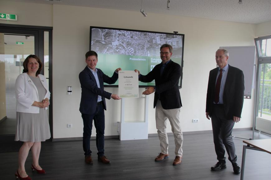 Der Parlamentarische Staatssekretär des Bundesumweltministeriums Florian Pronold übergibt dem Bürgermeister der Stadt Harzgerode eine Förderurkunde.