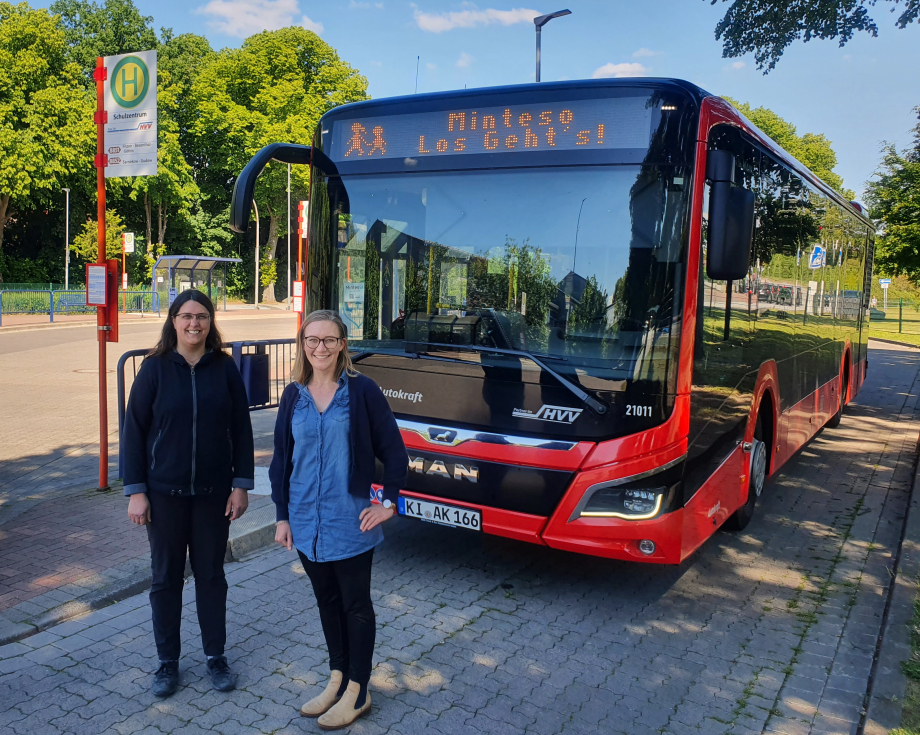 Zwei Personen stehen vor einem Schulbus