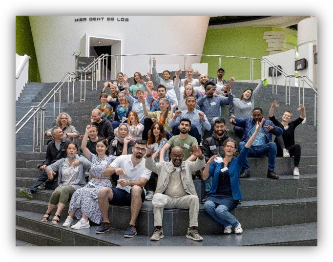 Die Teilnehmer der KlimaGesichter-Fachwerkstatt 2021 sitzen auf einer Treppe.