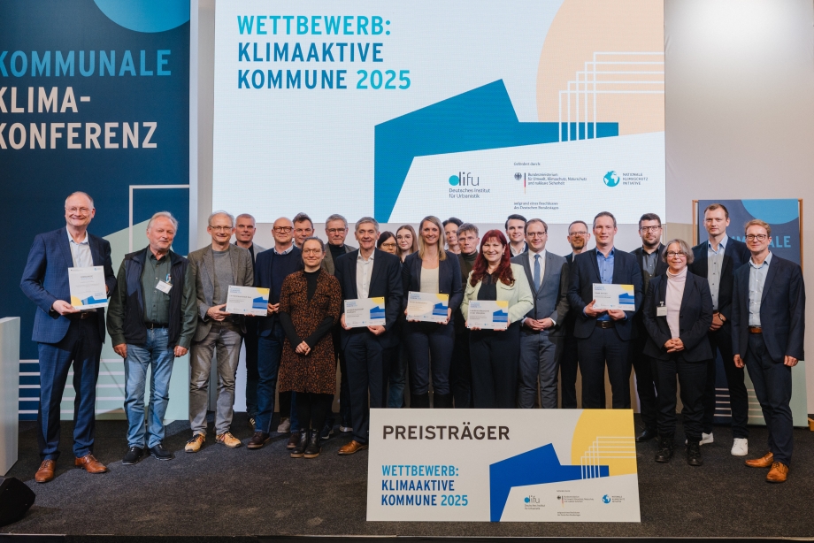 Strahlende Gesichter bei den Preisträgerinnen und Preisträgern auf der Bühne der Kommunalen Klimakonferenz in Berlin