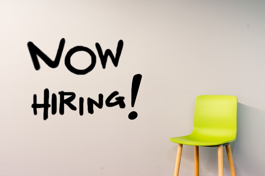 Das Bild eines Stuhls in grüner Neonfarbe. Links der Text: Now Hiring!