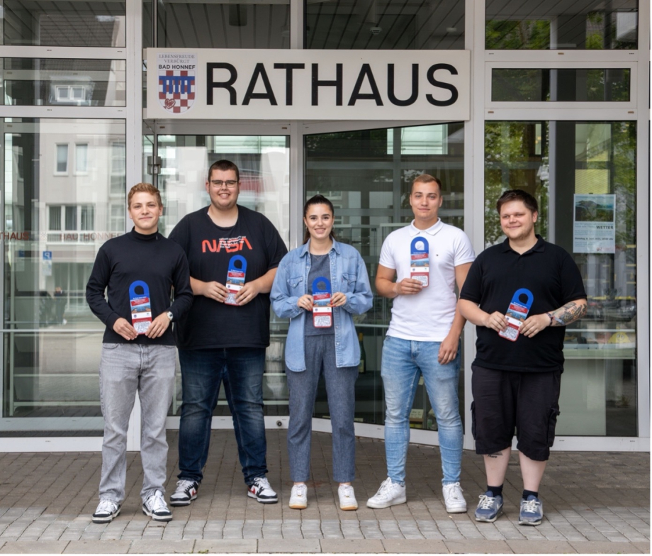 Fünf Jugendliche stehen vor dem Rathaus der Stadt Bad Honnef und halten Flyer in den Händen.