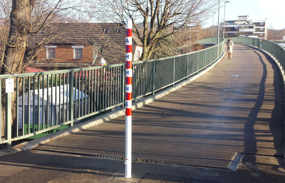 Eine Brücke mit Fahrradweg. Am Anfang des Radwegs ist mittig ein rot-weiß gestreifter Absperrpoller installiert.