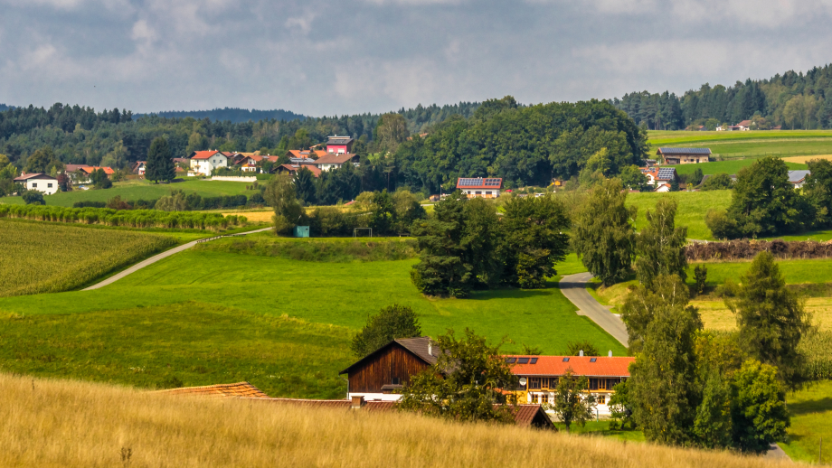 Das Foto zeigt die Luftaufnahme eines ländlichen Gebiets mit Feldern, Bäumen, Wäldern und vereinzelten Häusern. 