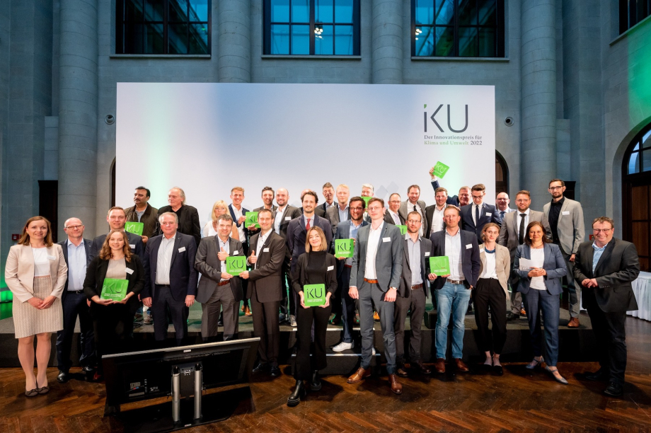 Preisträgerinnen und Preisträger des IKU 2022 auf der Bühne mit ihren Pokalen
