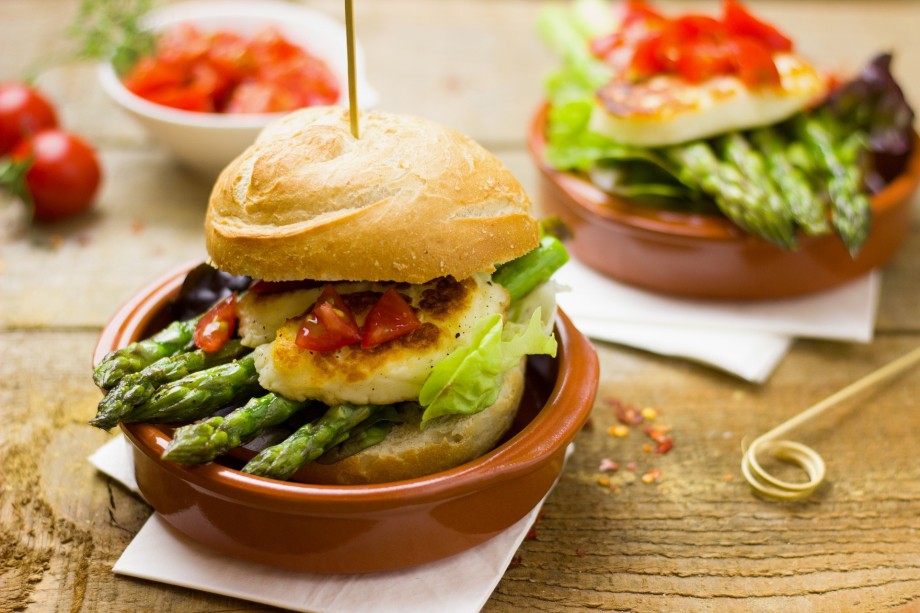 Das Bild zeigt vegetarische Speisen in Schälchen, darunter einen Hamburger mit Spargel.
