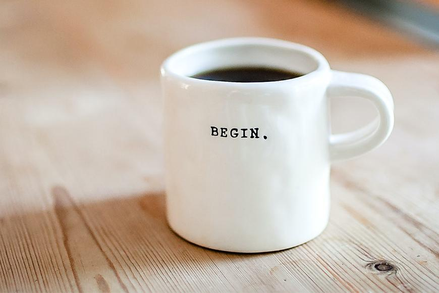 Zu sehen ist eine Kaffeetasse auf einem Holztisch