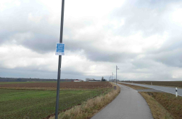 Eine solarbetriebene Beleuchtungsanlage neben einem Radweg.