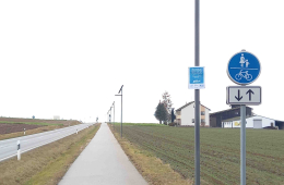 Eine solarbetriebene Beleuchtungsanlage neben einem Radweg.