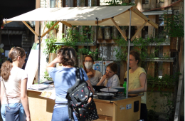 Personen informieren sich an einem mobilen Infostand