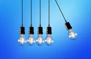 Das Bild zeigt fünf hängende LED-Lampen, die sich gegenseitig anschubsen.