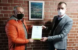 Das Bild zeigt Markt Schwabens Bürgermeister Michael Stolze und Joachim Fischer, Projektleiter und Leiter Gebäudemanagement in Markt Schwaben, mit dem Klimaschutz-Zertifikat in den Händen.