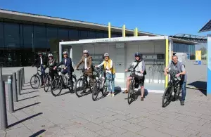 Das Bild zeigt die Geschäftsführung und Mitarbeitende der Messe Stuttgart mit E-Bikes vor der neuen Chargercube-Ladestation.