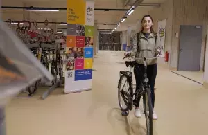 Das Bild zeigt eine Studierende mit ihrem Fahrrad in der neuen Fahrradstation an der Universität zu Köln.