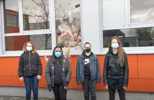Das Bild zeigt vier Schülerinnen der Gesamtschule Langerfeld in Wuppertal vor dem Schulgebäude.