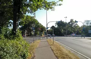 Ein Foto von einem Radweg neben einer Straßenkreuzung und einer Ampelanlage.