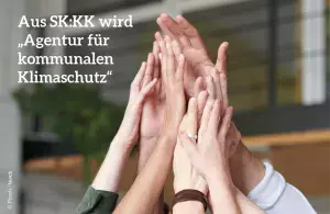 Das Foto zeigt viele Hände, die sich gemeinsam in der Mitte in einer Art High Five treffen. Daneben der Text: Aus SK:KK wird "Agentur für kommunalen Klimaschutz"