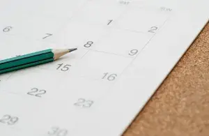 Nahaufnahme des Bleistifts auf dem Holztisch, unter Verwendung als schriftliche Agenda oder wichtiges Memo und Termin und Planung auf dem Kalender.
